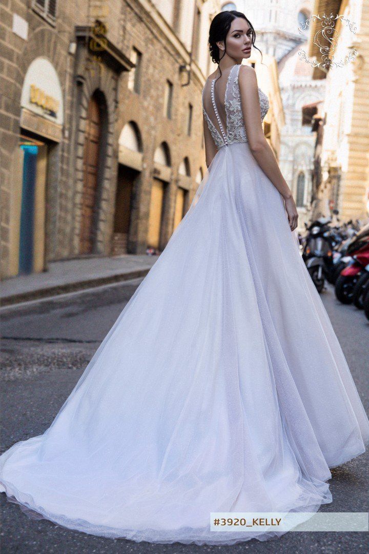 Eine Frau in einem weißen Brautkleid steht auf einer Stadtstraße.