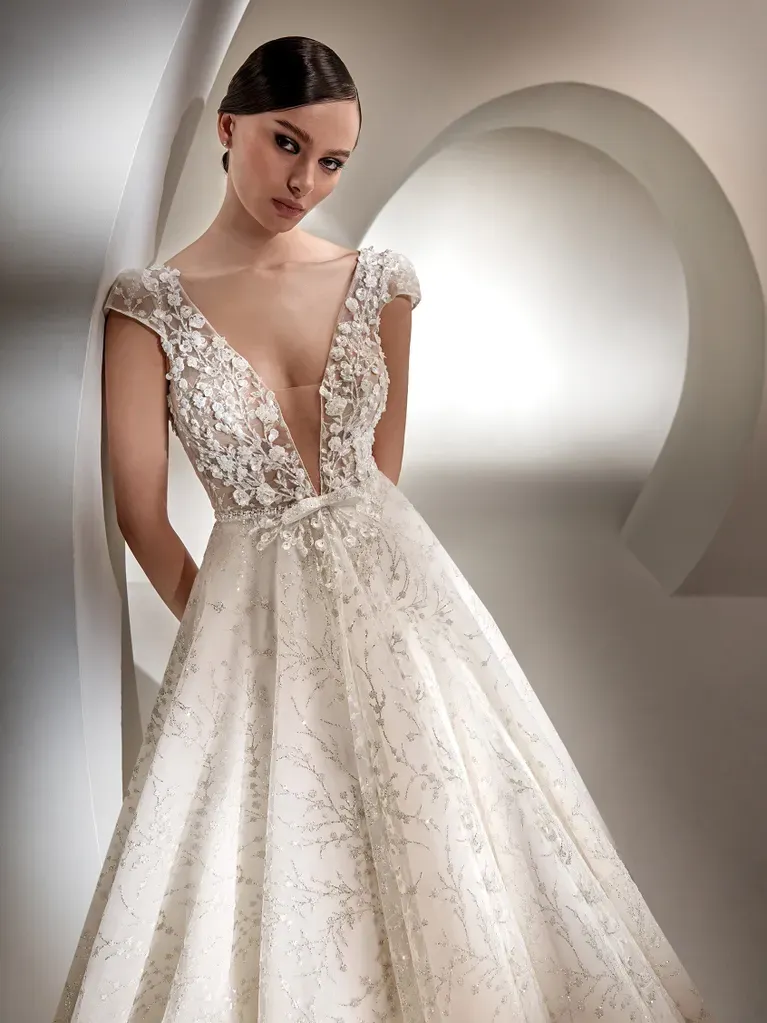 Eine Frau trägt ein weißes Brautkleid mit tiefem Ausschnitt.