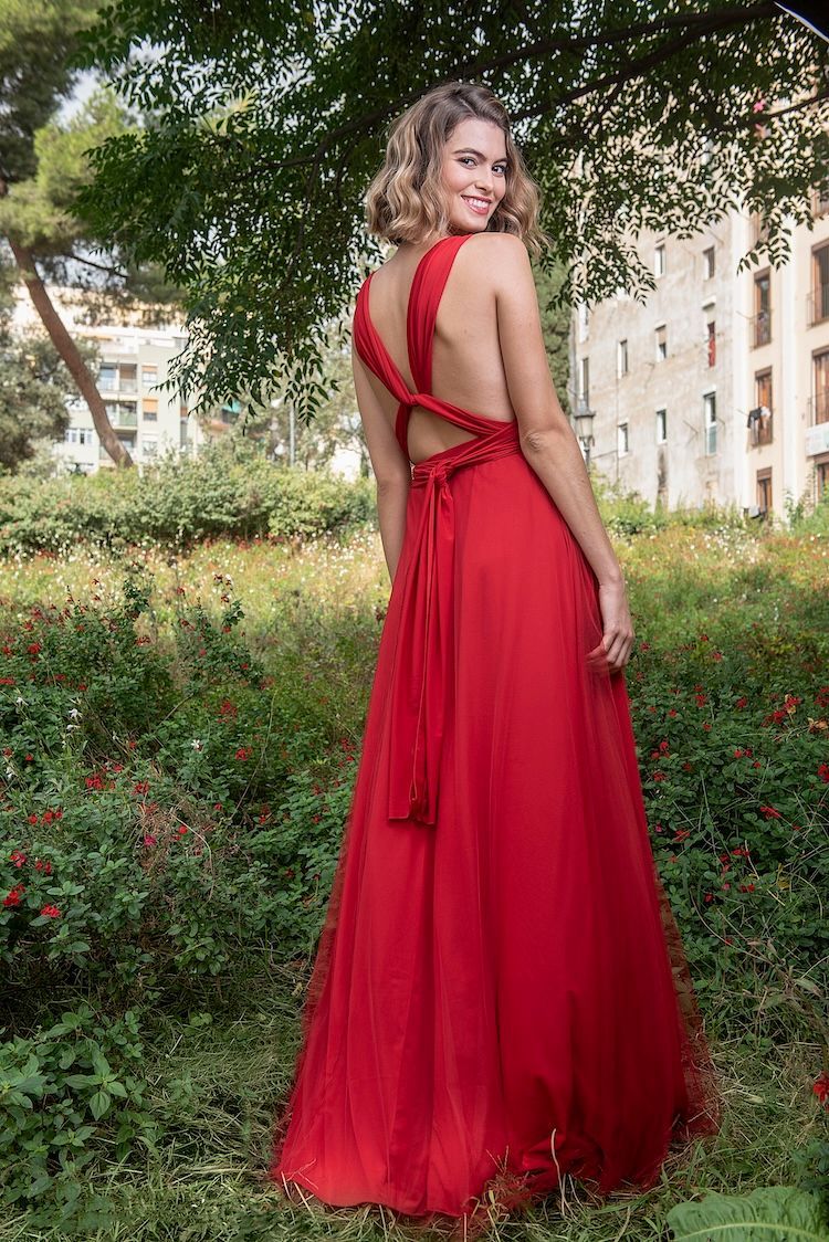 Eine Frau in einem roten Kleid steht auf einem Blumenfeld.