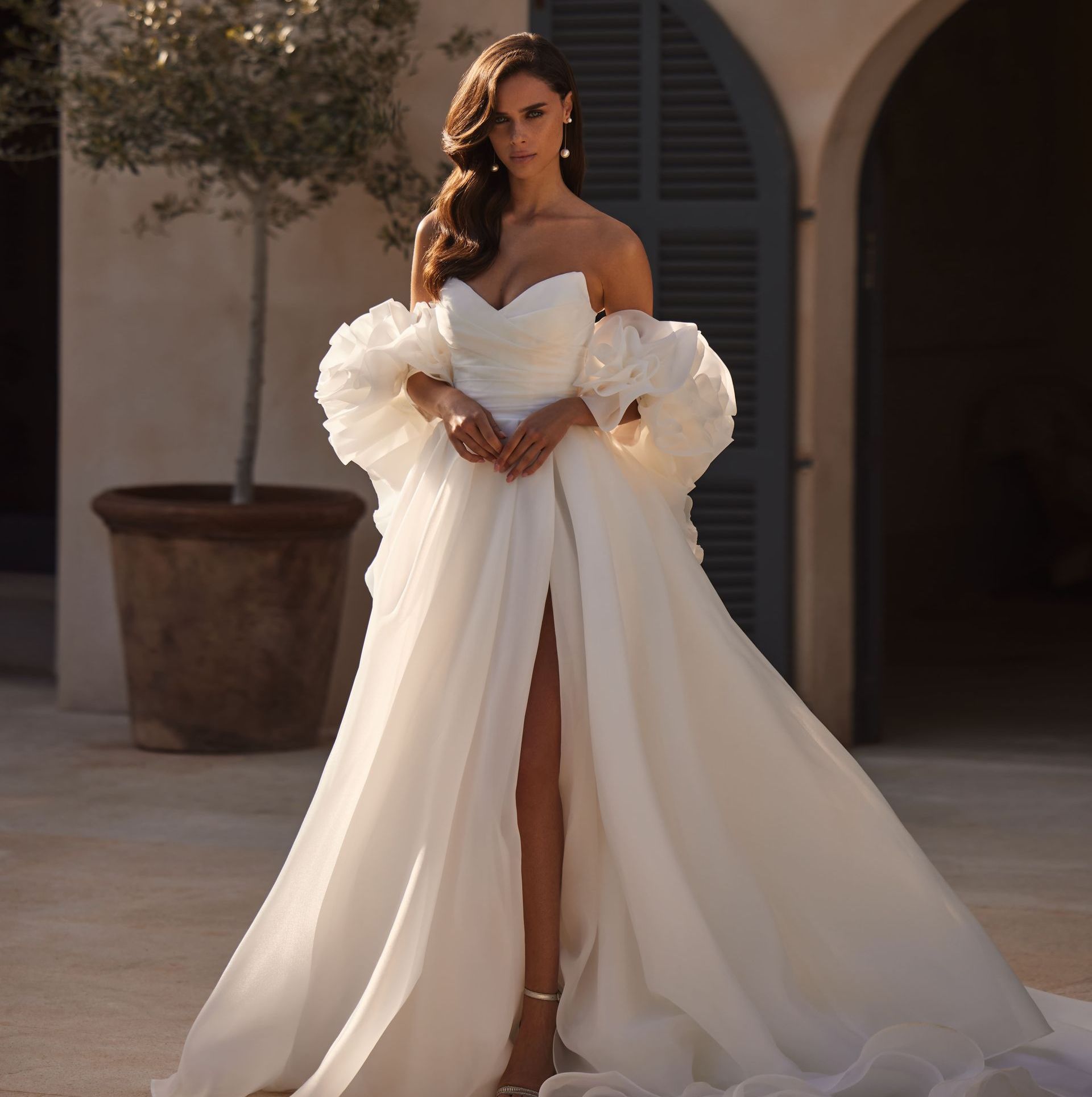 Eine Frau in einem weißen Brautkleid mit Rüschenärmeln
