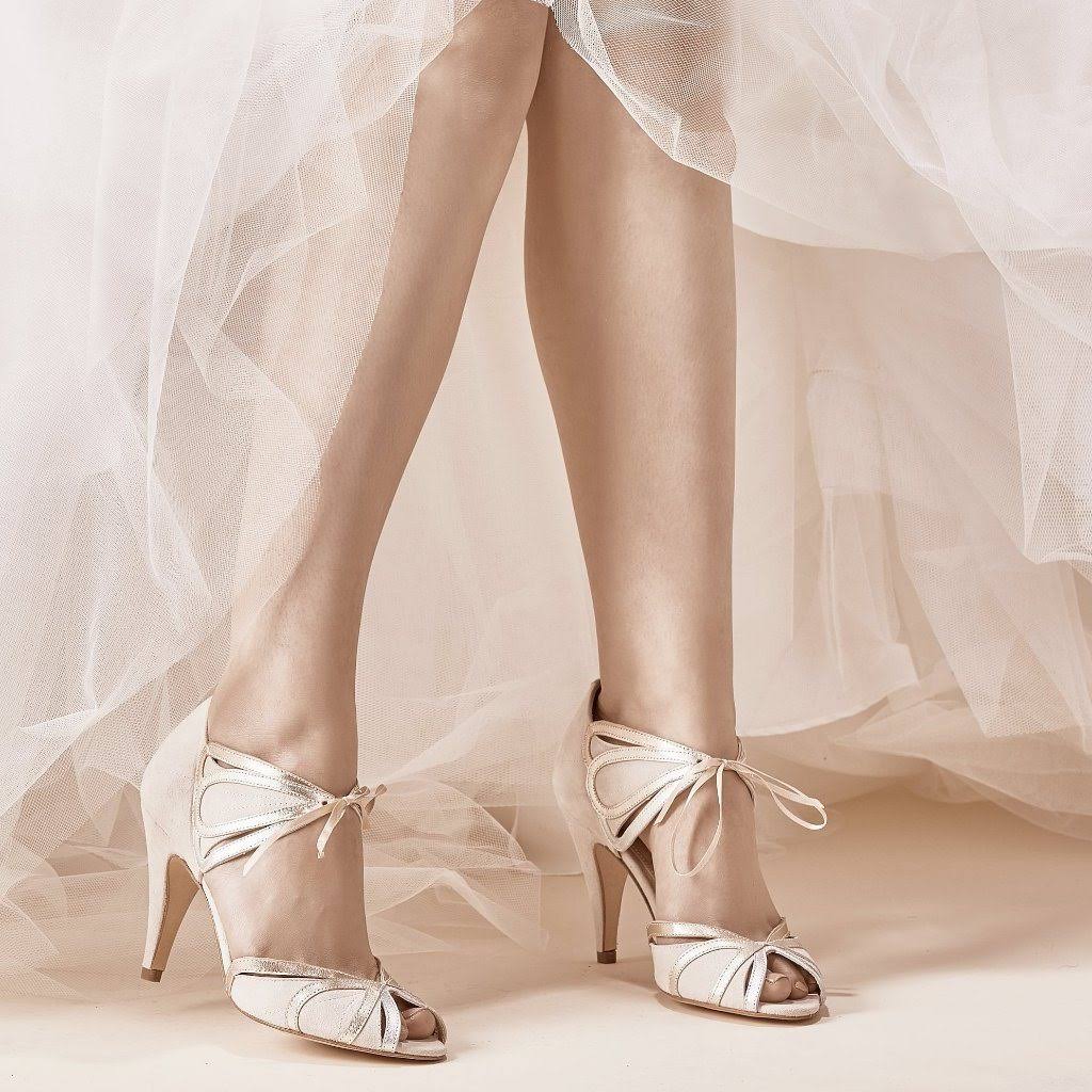 Eine Frau in einem Brautkleid trägt ein Paar weiße Schuhe