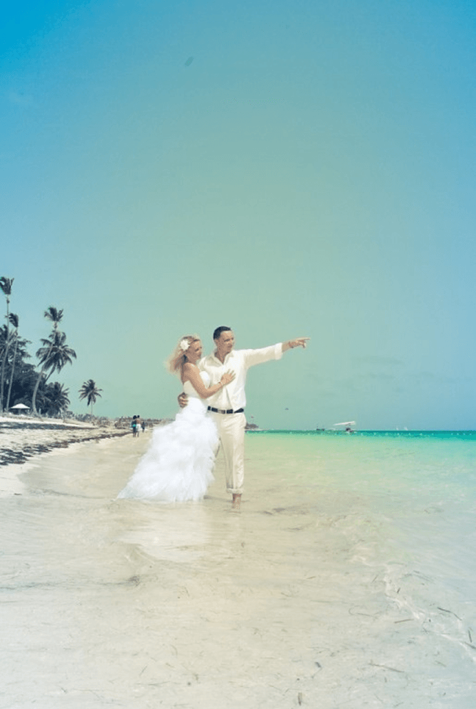 Eine Braut und ein Bräutigam gehen am Strand spazieren.