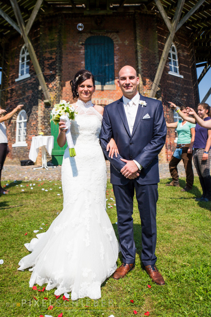 Eine Braut und ein Bräutigam posieren vor einem Gebäude für ein Foto.