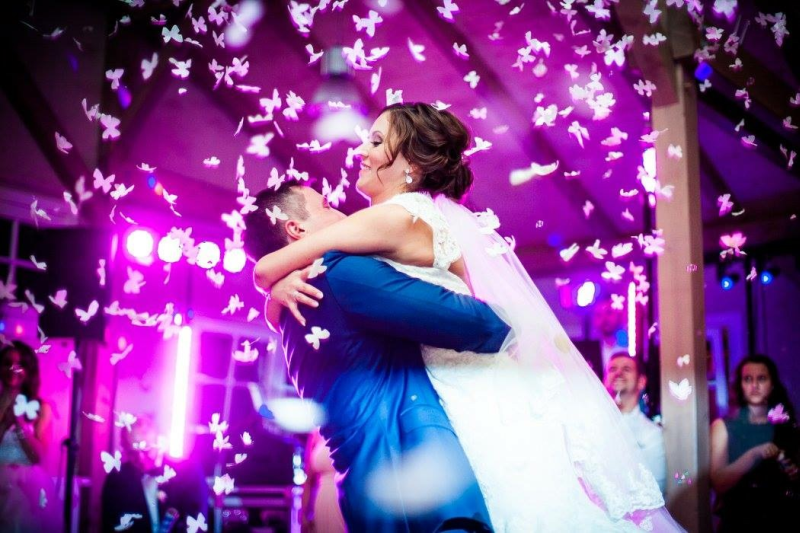 Eine Braut und ein Bräutigam küssen sich beim Tanzen auf ihrer Hochzeitsfeier.