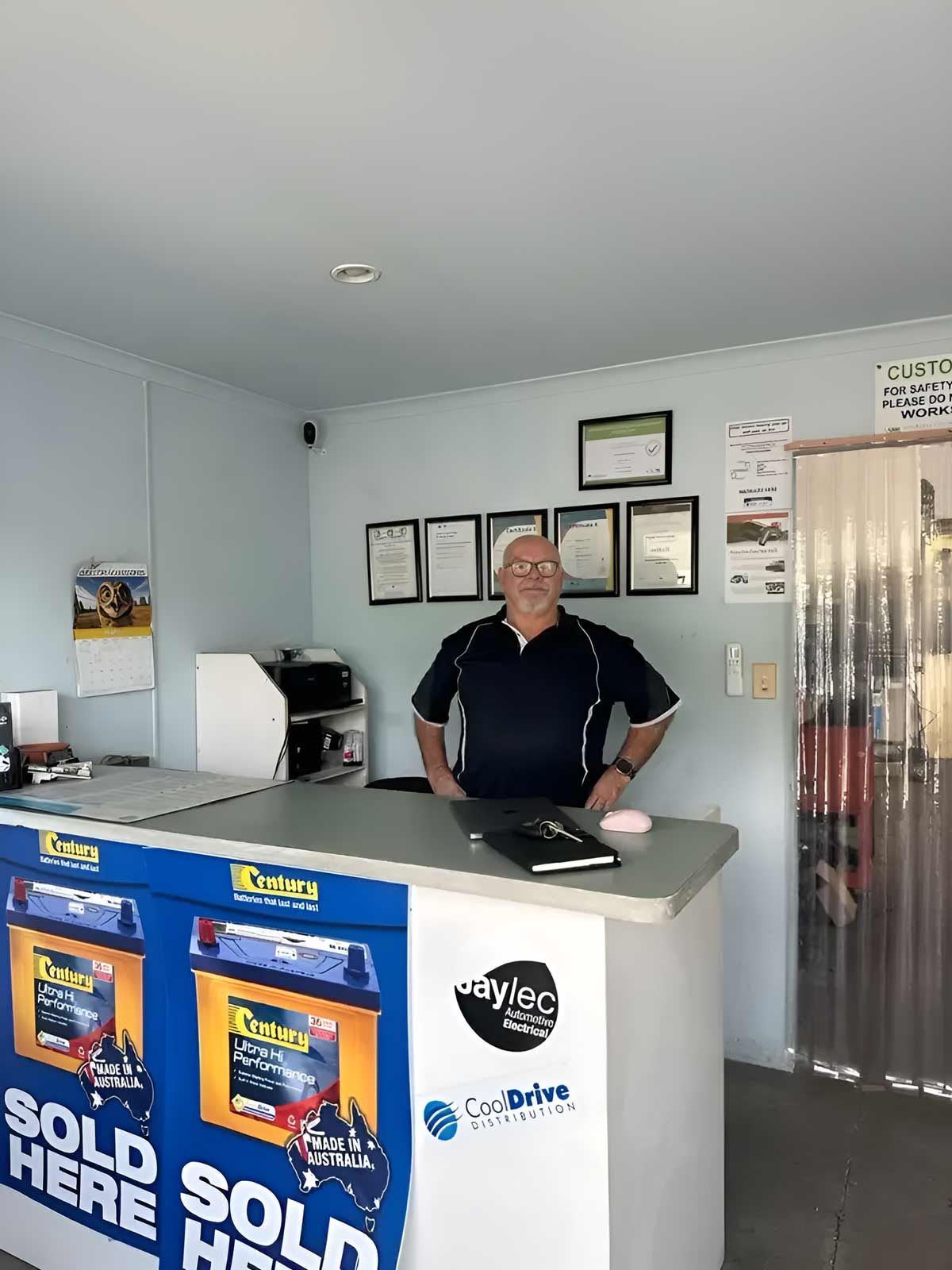 A Man Is Standing Behind A Counter In A Store — Barron River Auto Electrics & Air-conditioning in Stratford, QLD
