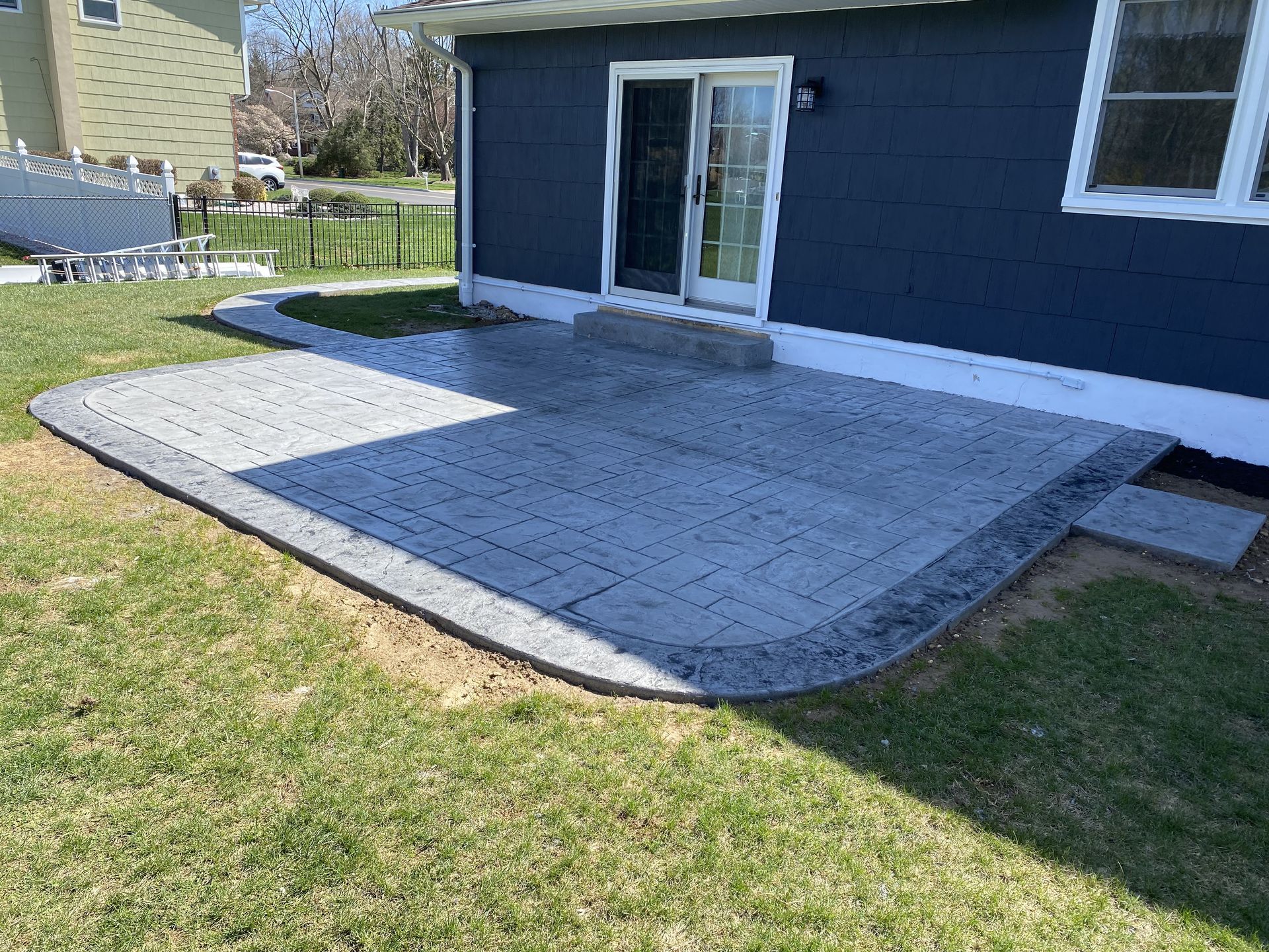 A blue house with a patio in front of it.