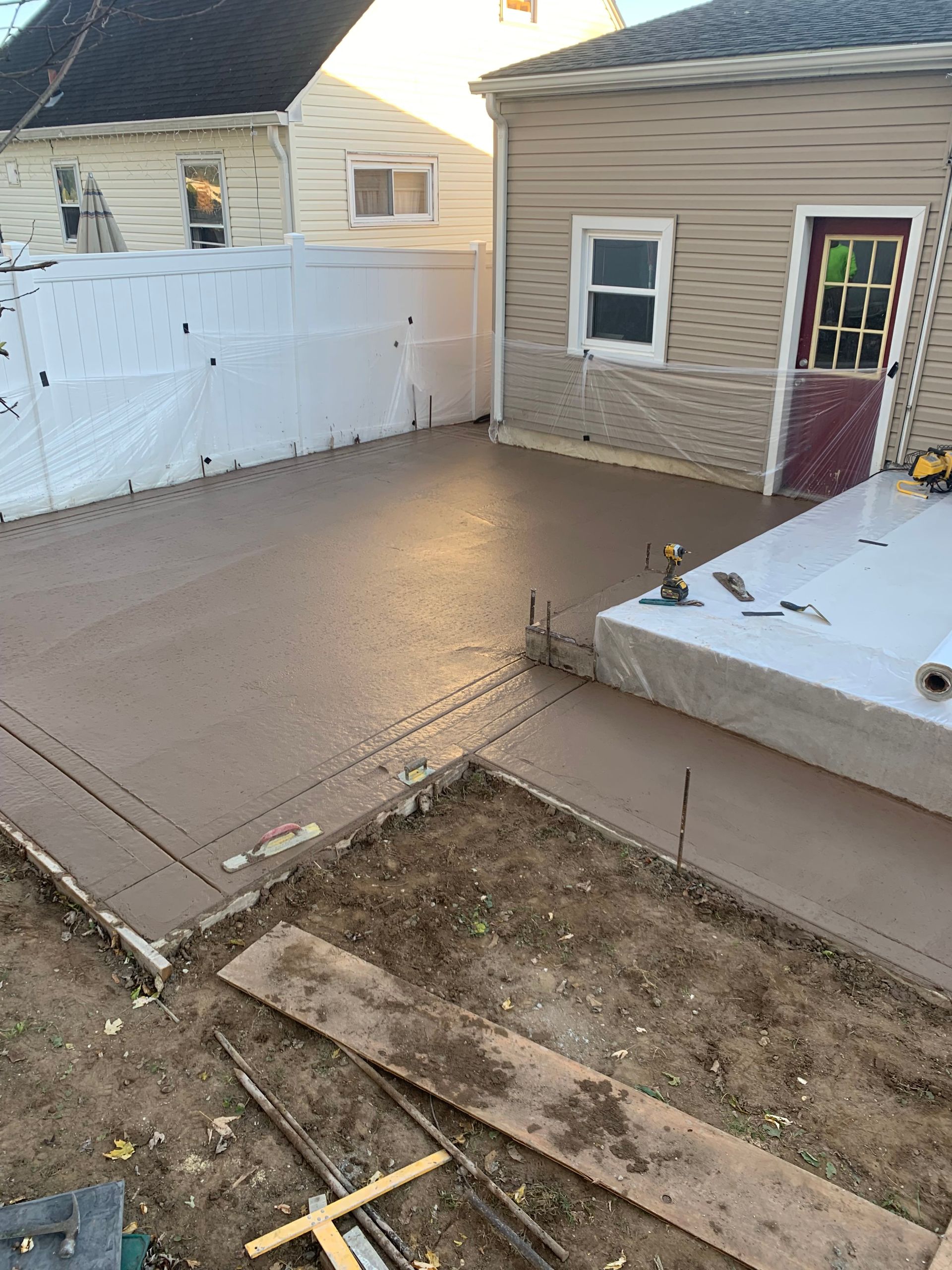 A concrete driveway is being built in front of a house.