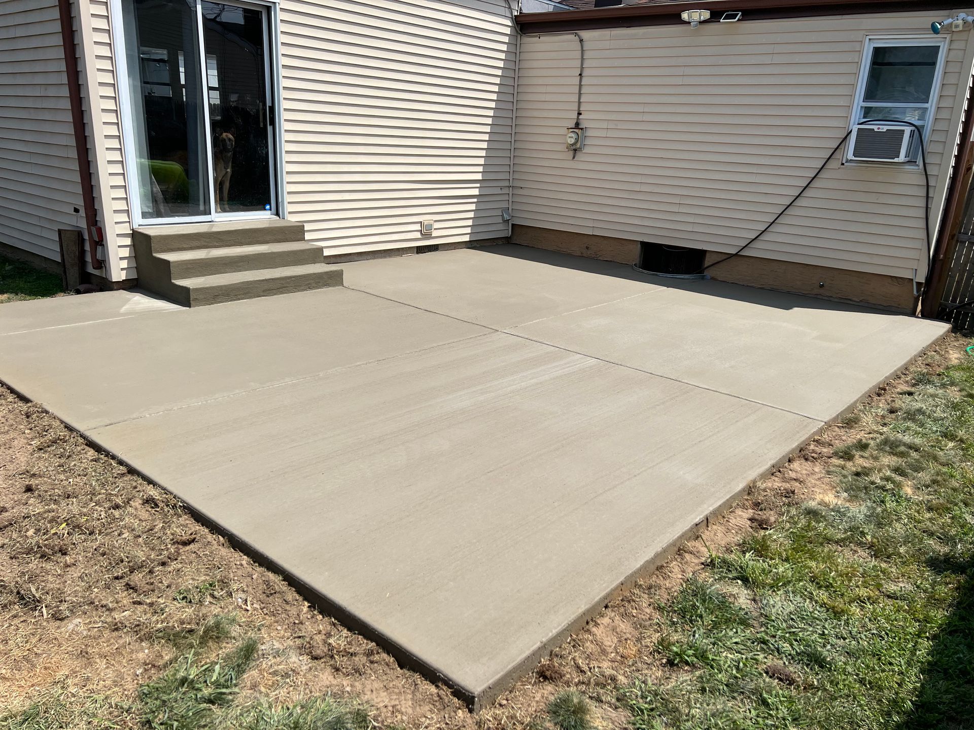 A concrete patio is being built in front of a house.