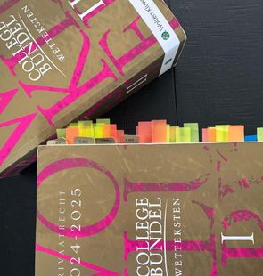 Een boek genaamd college bundel ligt op een tafel