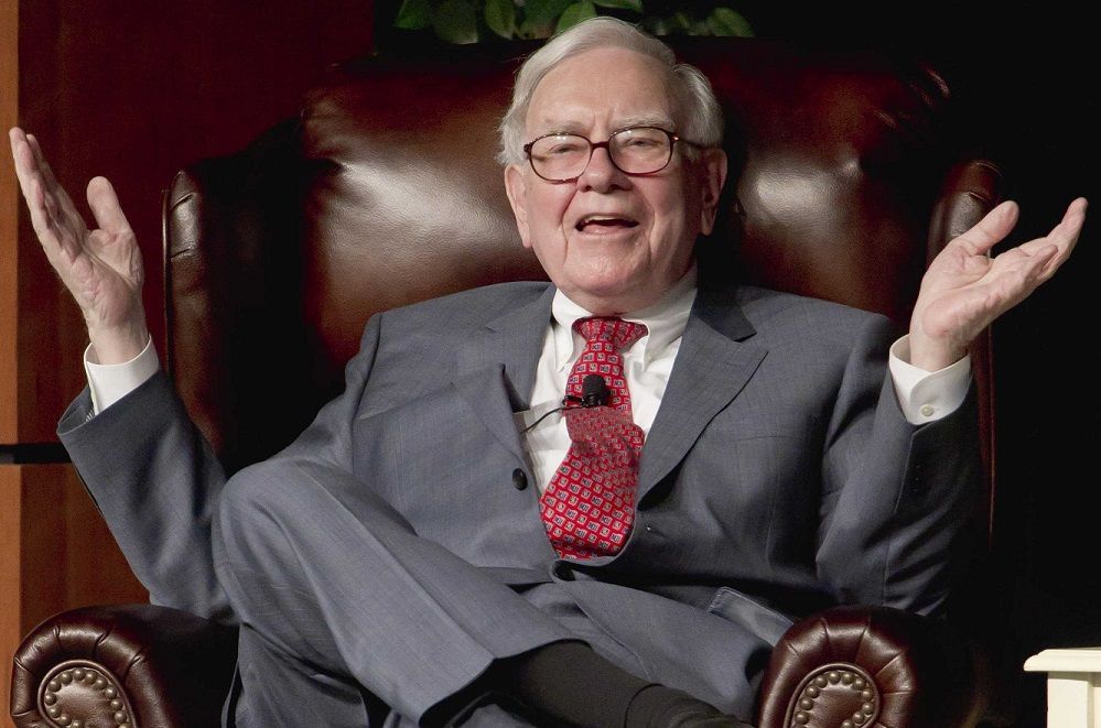 A man in a suit and tie is sitting in a chair with his arms outstretched.