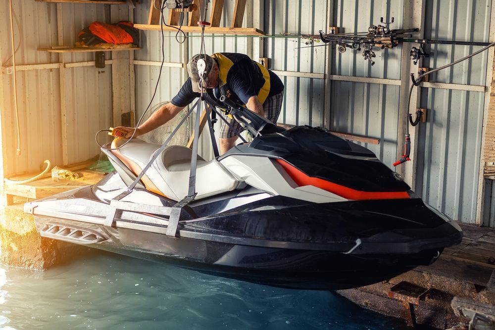 Person Lifting a Black and White Jet Ski With — ASAP Batteries & Breakdowns in Burleigh Heads, QLD