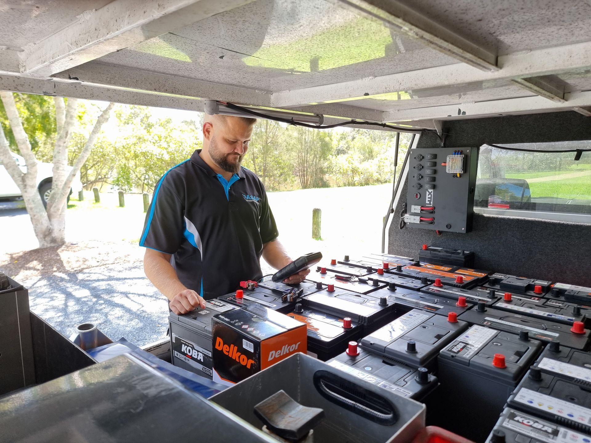 Man in a Utility Vehicle Inspecting Batteries — ASAP Batteries & Breakdowns in Burleigh Heads, QLD