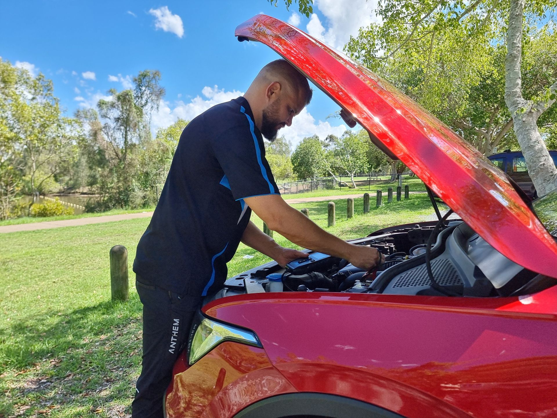 Man in Black Uniform Working on the Engine — ASAP Batteries & Breakdowns in Burleigh Heads, QLD