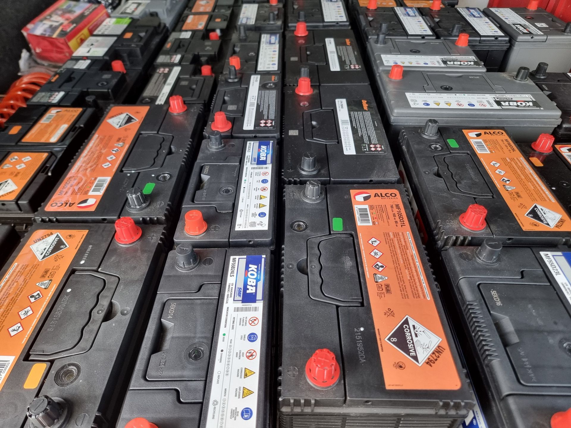 Rows of car batteries with red and orange terminals. — ASAP Batteries & Breakdowns in Burleigh Heads, QLD