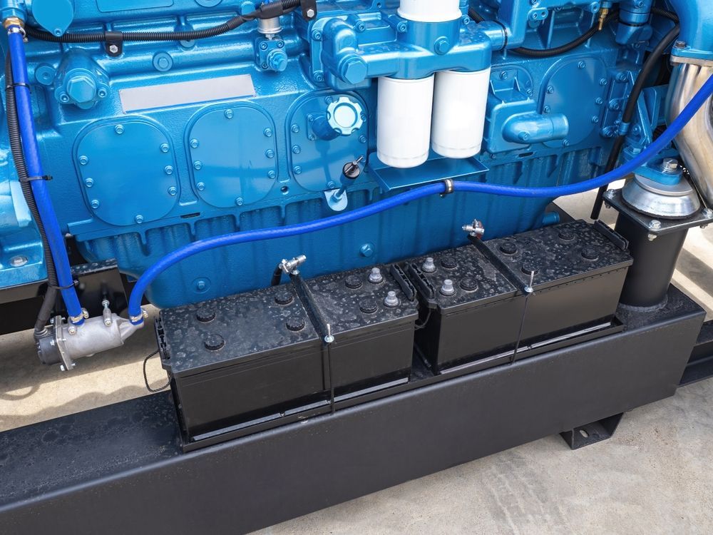 Blue Industrial Engine With Three Black Batteries in a Black Container — ASAP Batteries & Breakdowns in Burleigh Heads, QLD