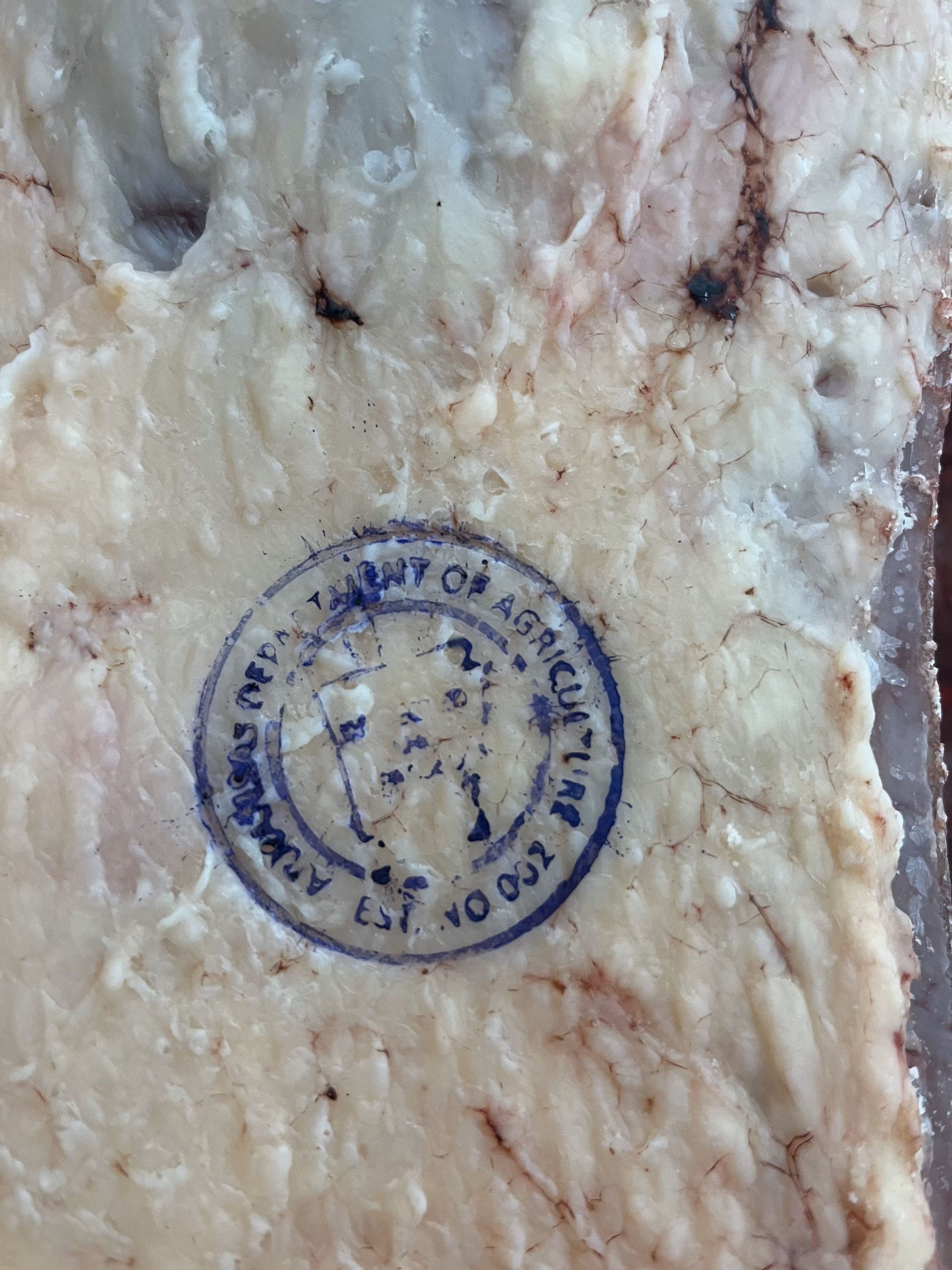 A piece of meat with a stamp that says county of agriculture
