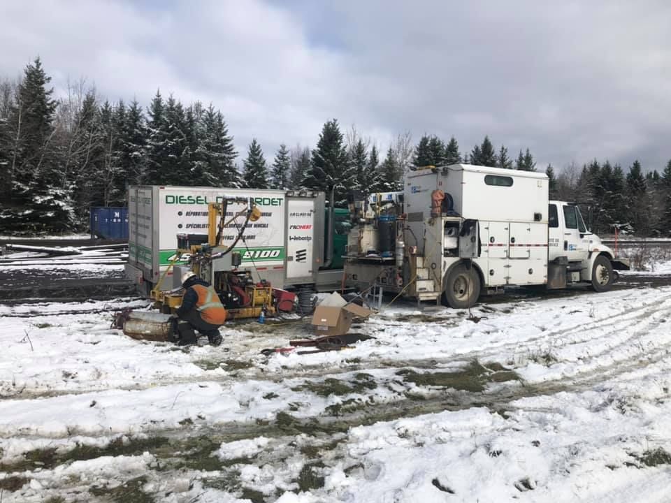 Deux camions sont garés dans un champ enneigé.