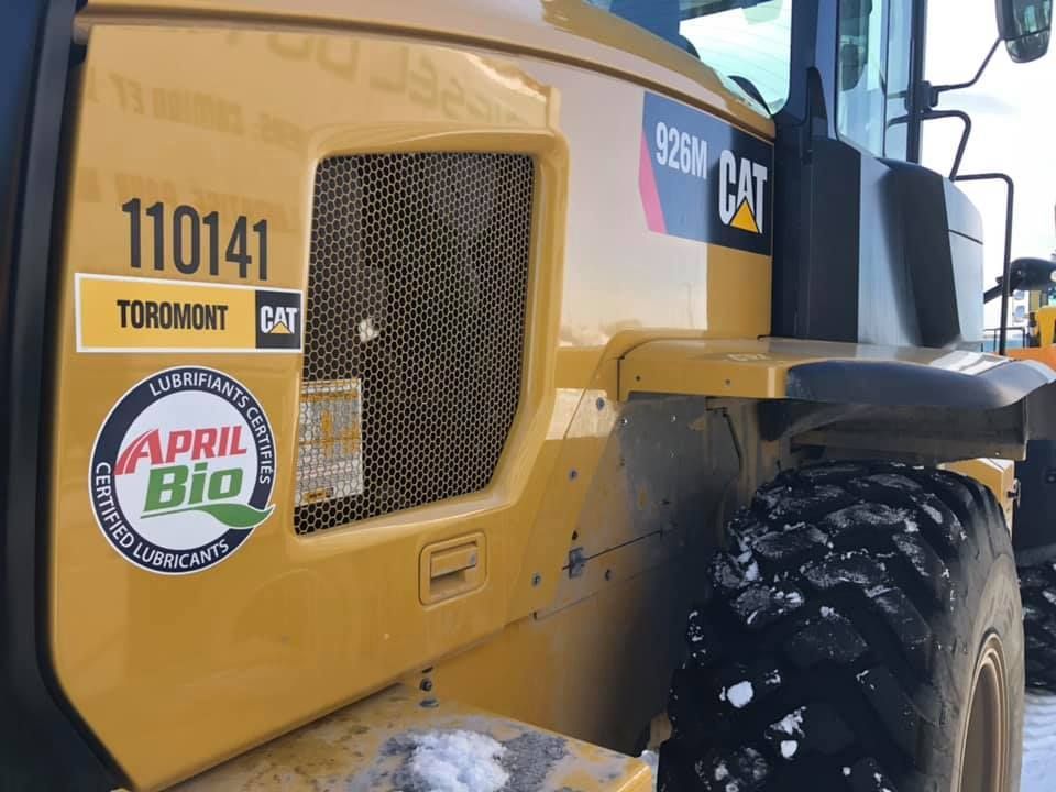 Un tracteur à chat jaune avec un autocollant sur le côté qui dit avril bio