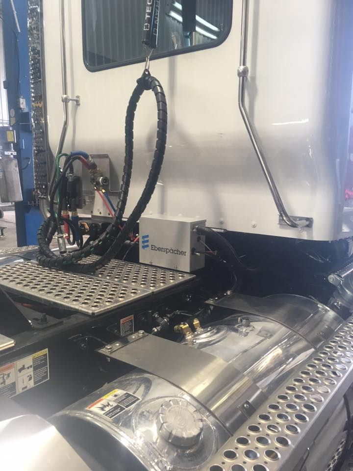 Un semi-remorque blanc est assis sur un ascenseur dans un garage.