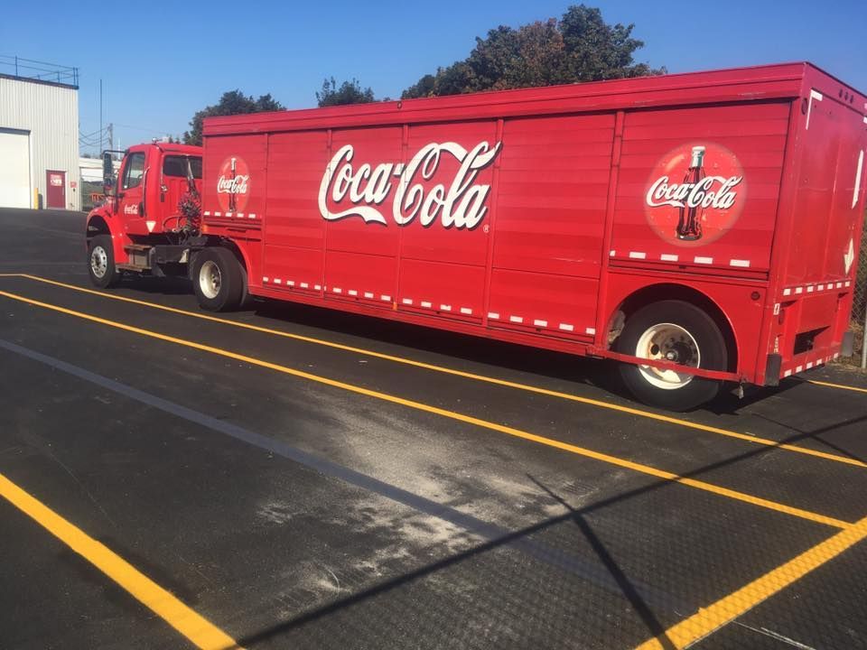Un camion de coca cola rouge est garé dans un parking