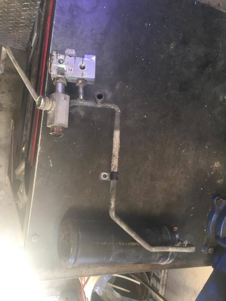 Un tuyau est connecté à une valve sur le côté d’une voiture.