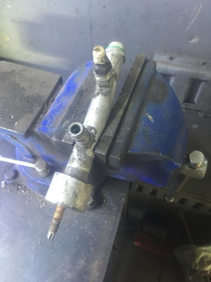 Un morceau de métal repose sur un étau bleu.