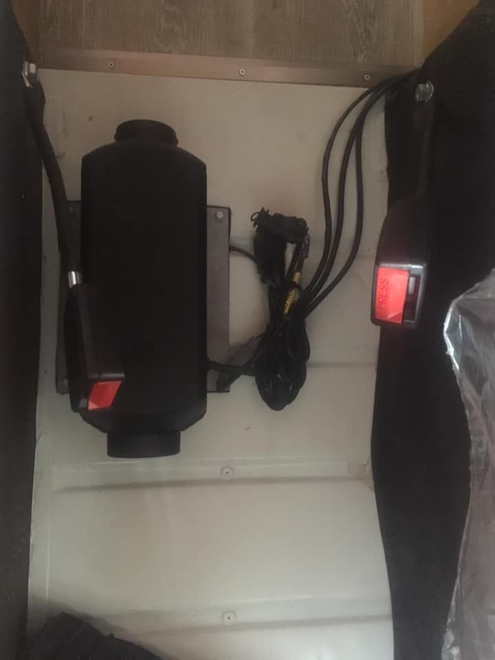 Un appareil noir avec un bouton rouge est accroché au mur.