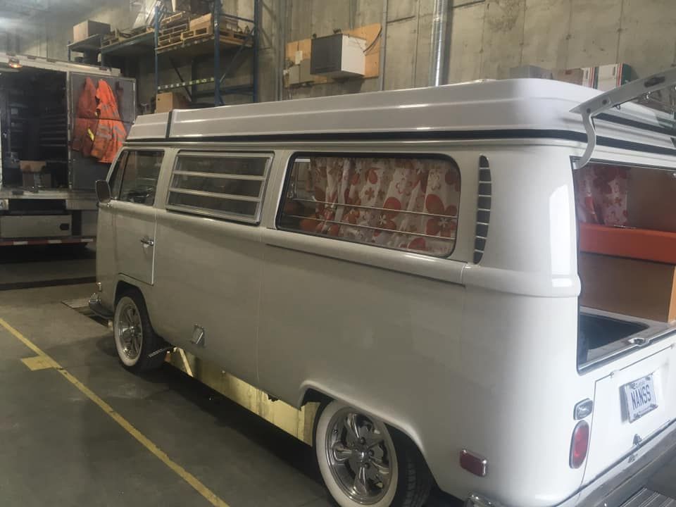 Une camionnette blanche est garée dans un garage à côté d'un camion.