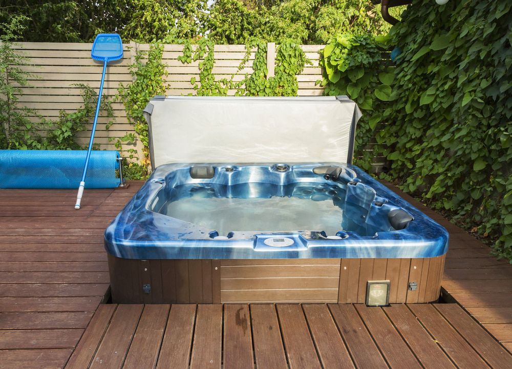Hot Tub on a Wooden Deck Surrounded by Greenery — Donna's Pool & Spa Centre In Port