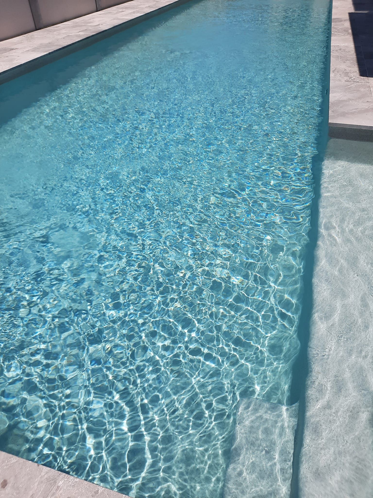 A Small Backyard Pool With a Metal Handrail — Donna's Pool & Spa Centre In Port Macquarie, NSW