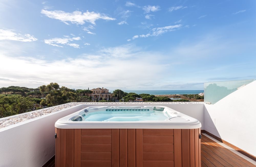 Hot Tub on a Rooftop Deck Overlooking the Ocean Under a Blue Sky — Donna's Pool & Spa Centre In Port