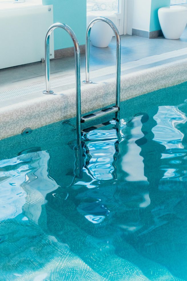 Pool Ladder in Turquoise Water, Close-up. Sunny Room, White Trim, Aqua Walls — Donna's Pool & Spa Centre In Port