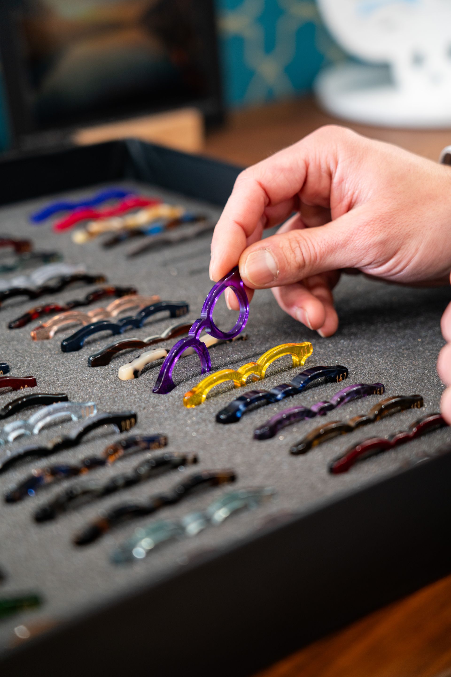 Ottico con gli occhiali riflesso in uno specchio all'interno di un negozio che espone occhiali.