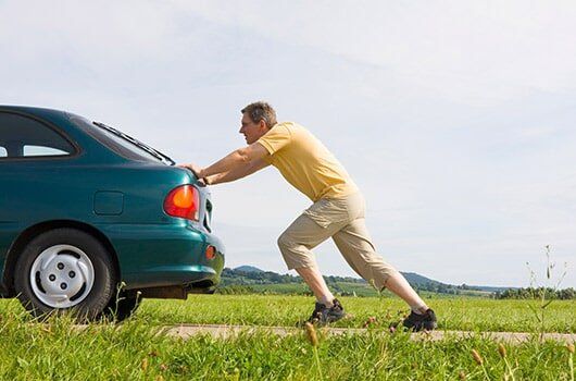 Junk Cars — Man Pushing His Car in Prosser, WA