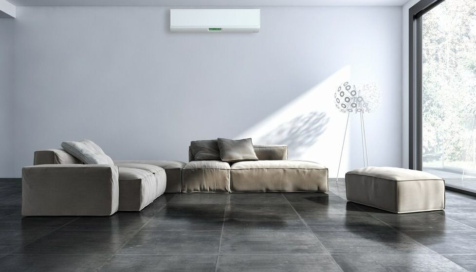 A Living Room With A Couch, Ottoman, And Air Conditioner — Ramm Air Conditioning In Port Macquarie, NSW