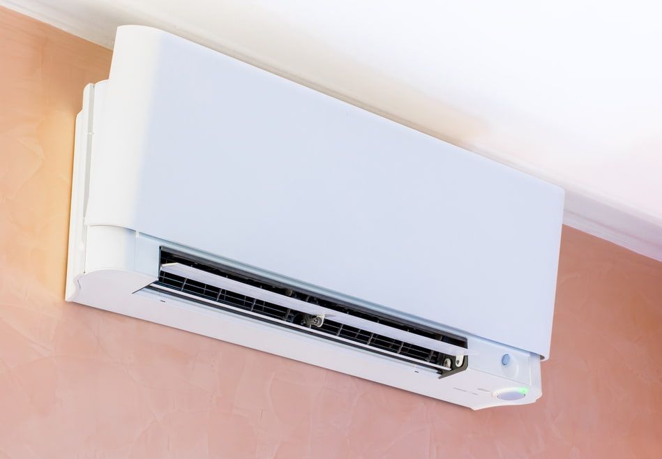 A White Air Conditioner Is Hanging From The Ceiling On A Wall — Ramm Air Conditioning In Port Macquarie, NSW