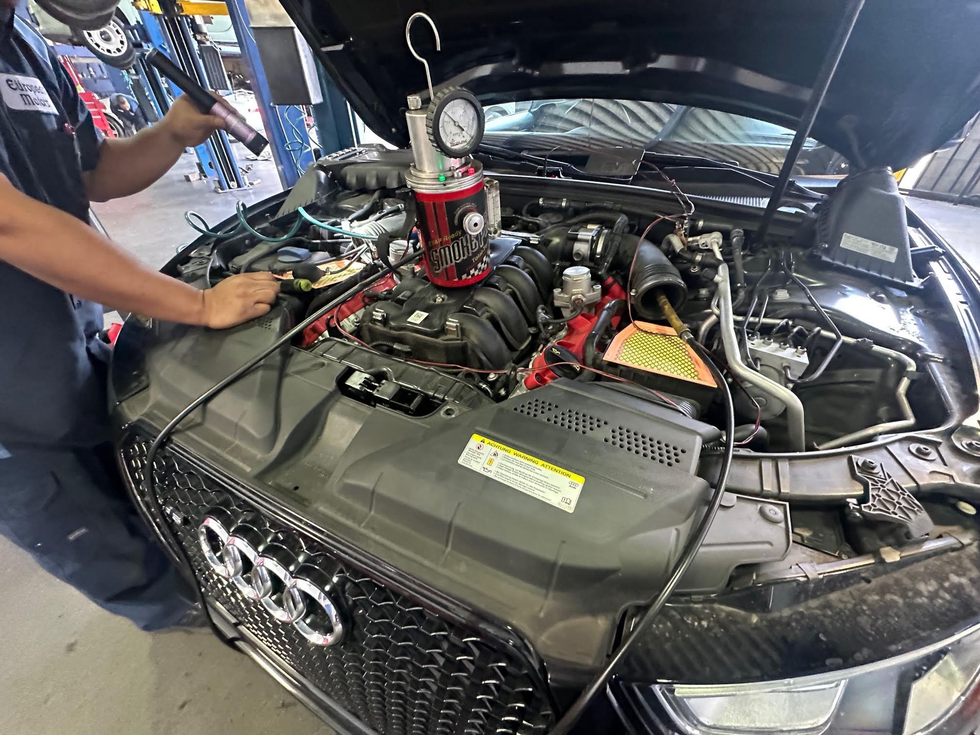 A man is working on the engine of a car.