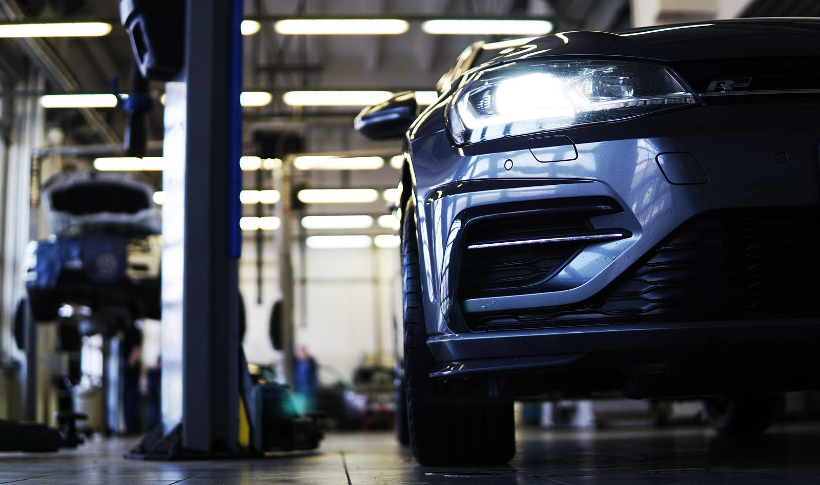A person is working on a car engine with a wrench.