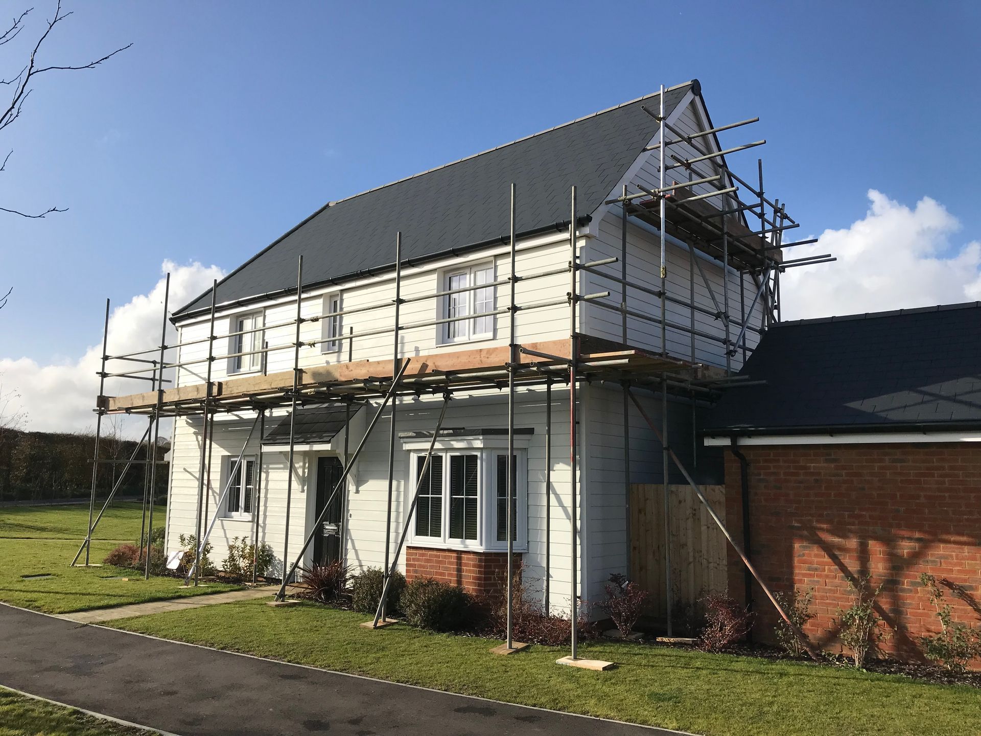 A house with scaffolding on it is being built.