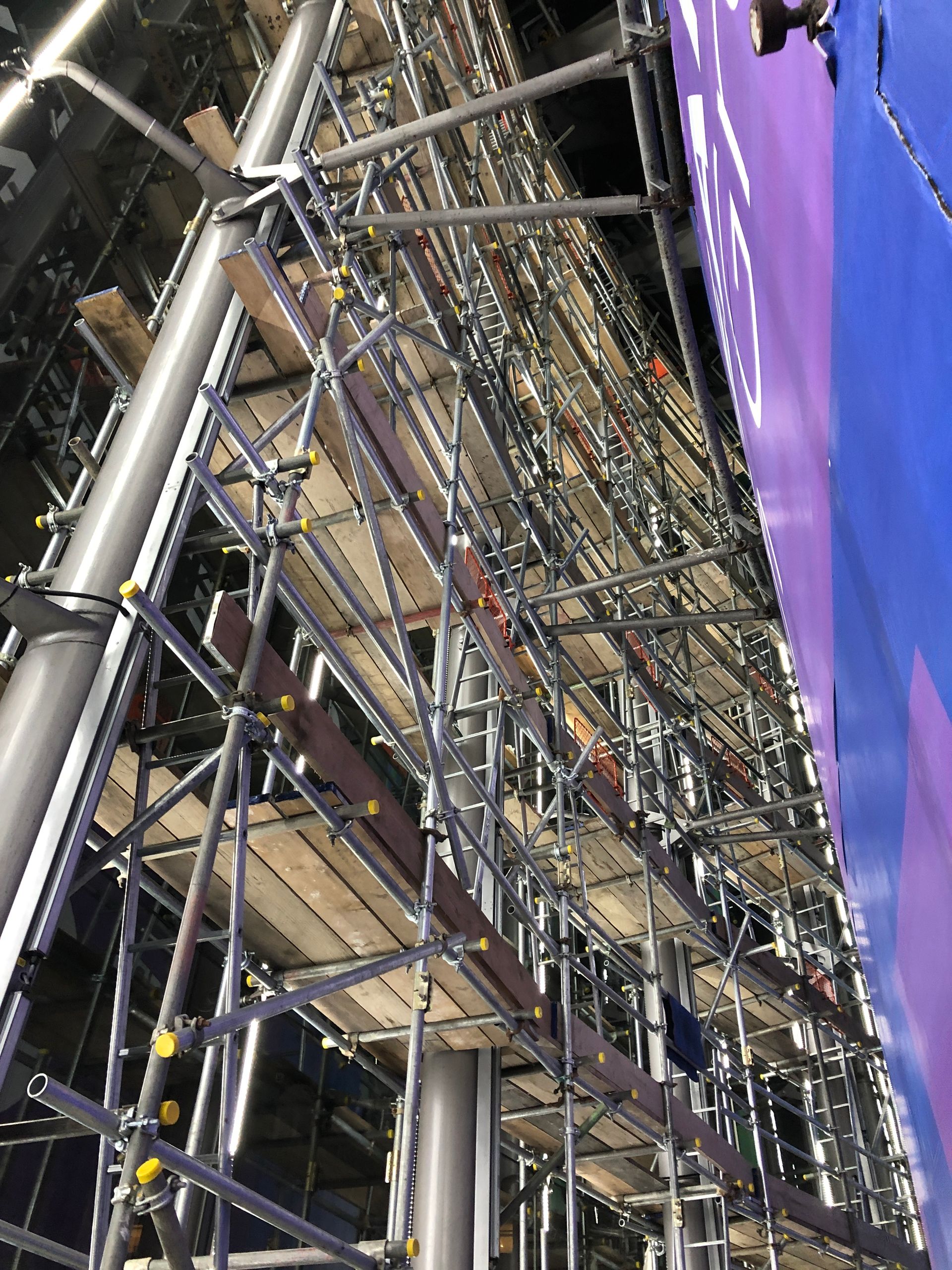 A large scaffolding structure is being built in a building