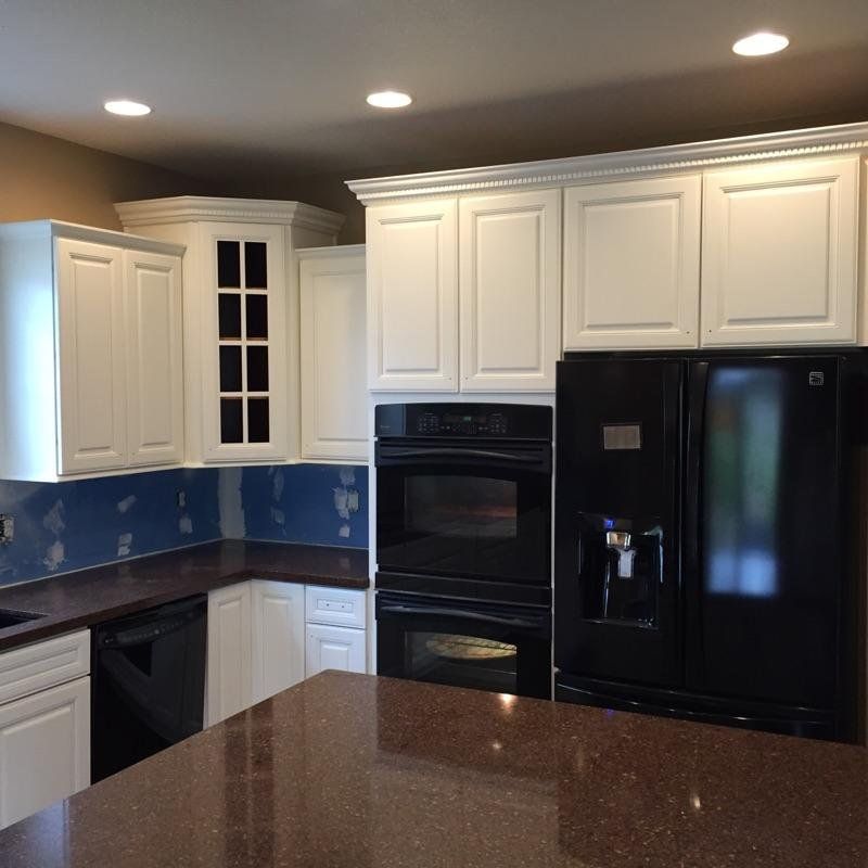Completed White painted kitchen with black countertops and black appliances