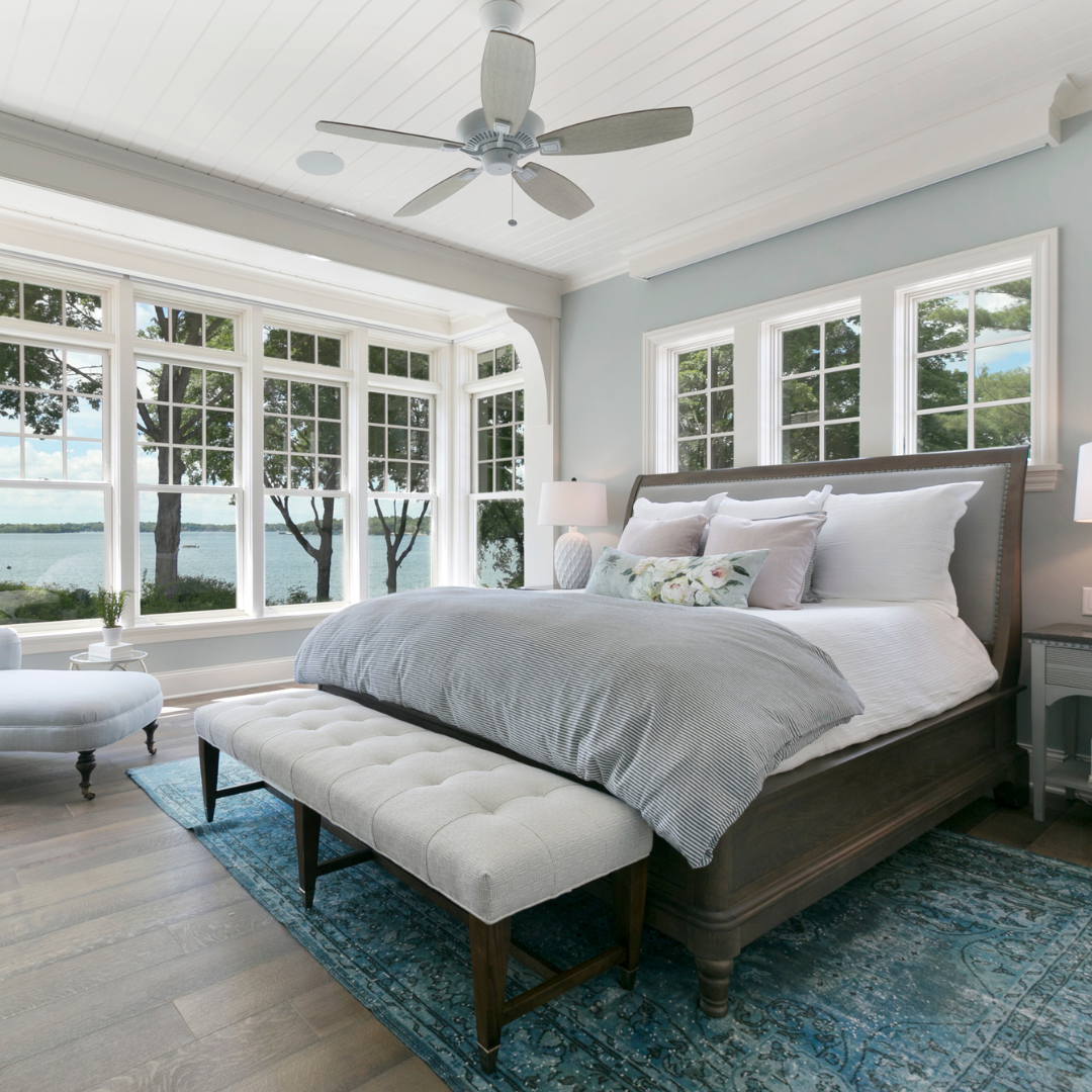 A bedroom with a large bed and a ceiling fan