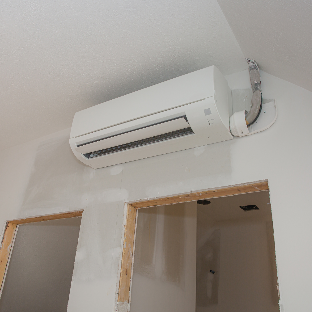A white air conditioner is mounted on a white wall