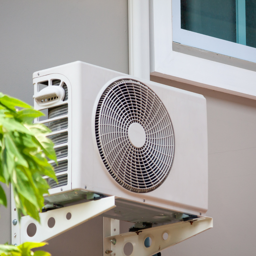 A fan is mounted on a wall next to a window