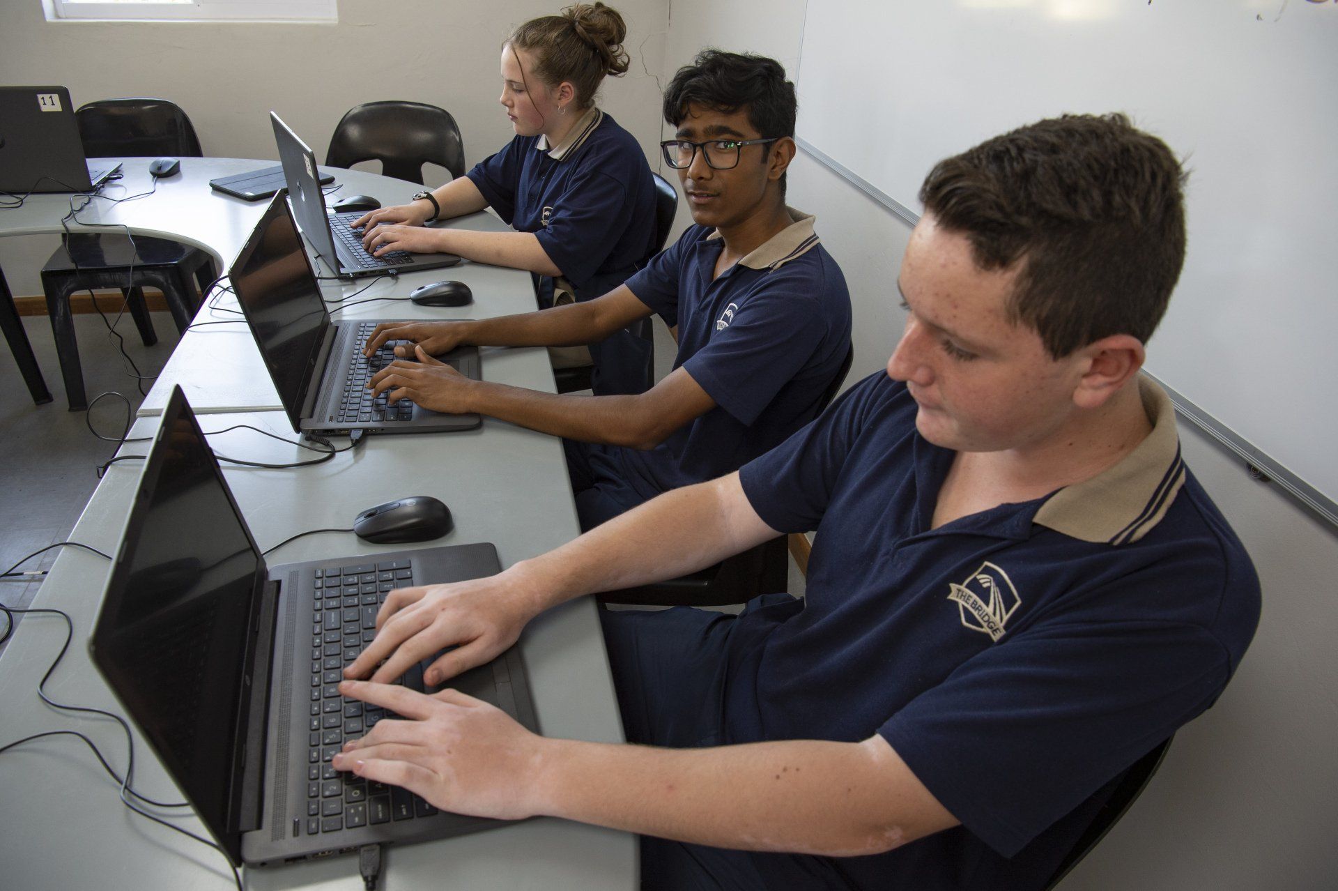 A group of students are using laptops in a classroom.