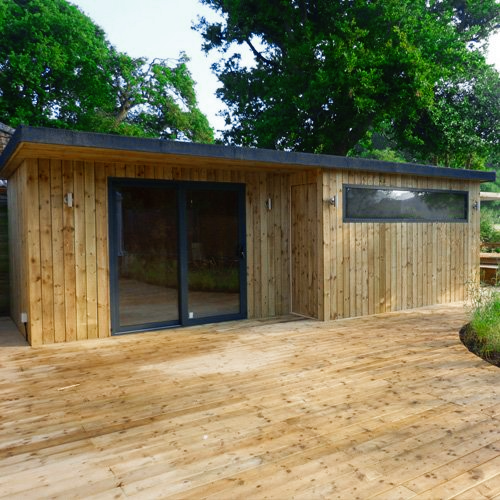 A stylish garden cabin with natural timber cladding, a spacious deck, and large windows designed for modern outdoor living.
