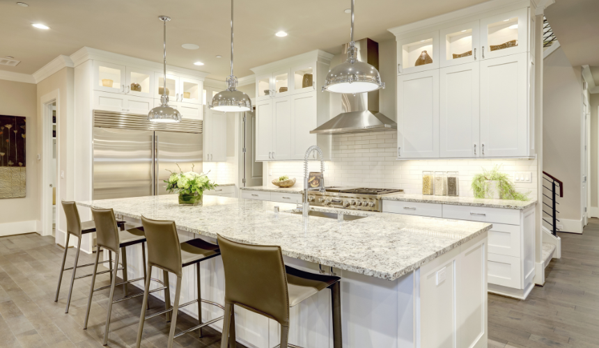 Timeless elegance meets modern functionality: A stunning white kitchen with stainless steel appliances and marble countertops.