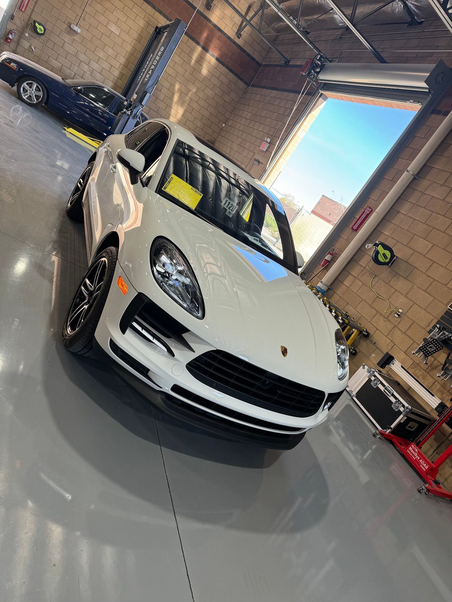 White Porsche Macan in a garage Discover Logo | Auto Dynamic Services LLC