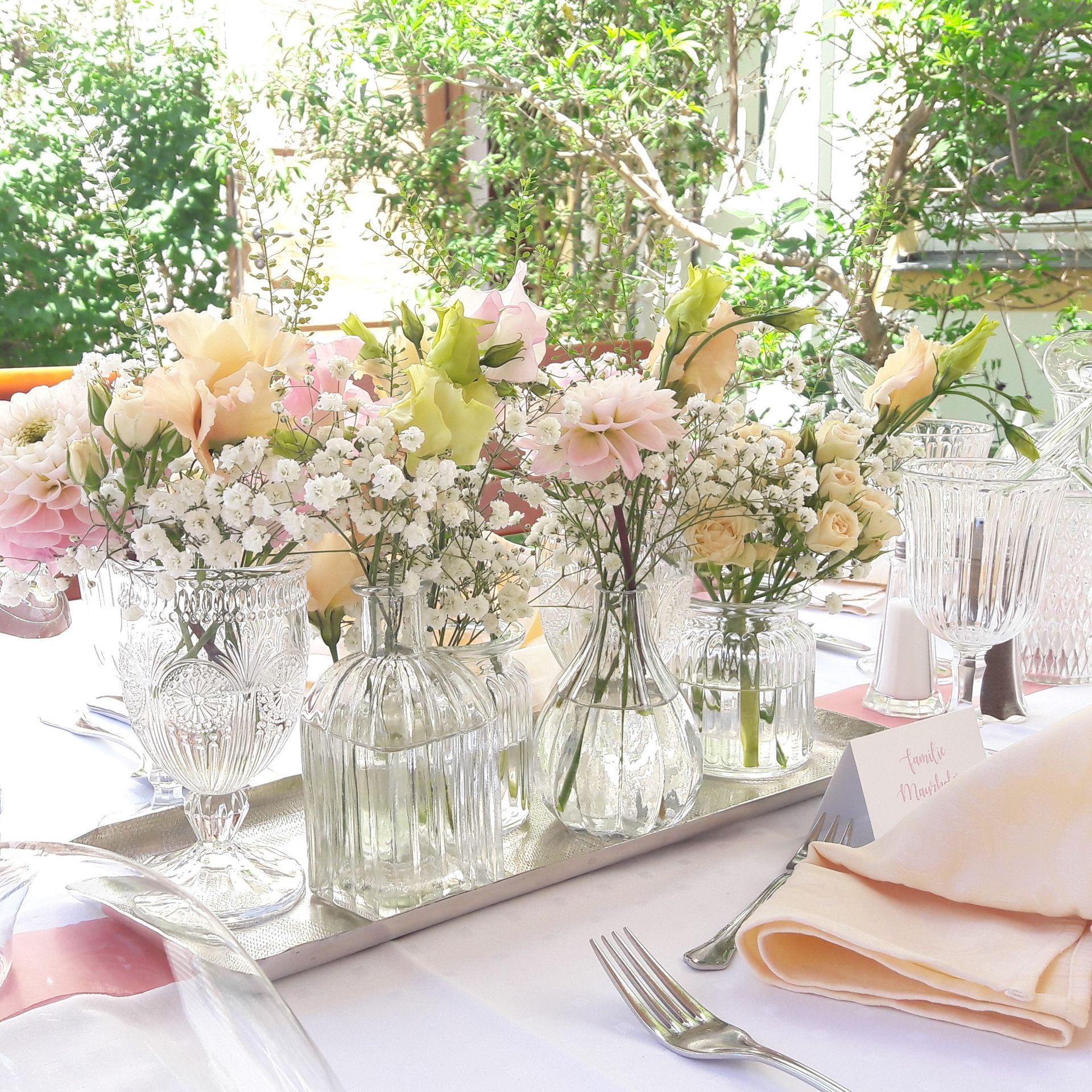 ein Tisch mit vielen Vasen mit Blumen darauf