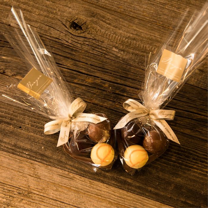 zwei Plastiktüten mit Schokoladenbonbons auf einem Holztisch